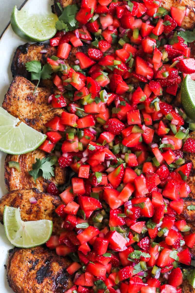 up close image of grilled chicken with strawberry salsa on platter