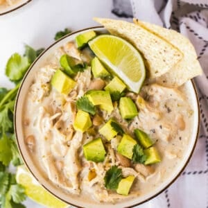 bowl of instant pot white chicken chili garnished with avocado and chips