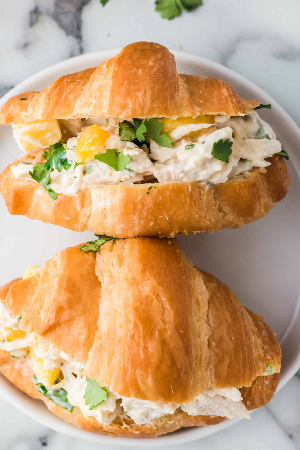 up close image of mango chicken salad sandwich on croissant