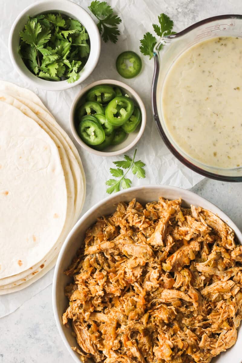 shredded chicken jalapenos and tortillas on a table