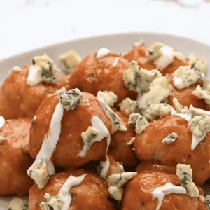 Buffalo chicken meatballs are topped with blue cheese.
