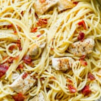 up close image of pasta with cream sauce, bacon, and chicken