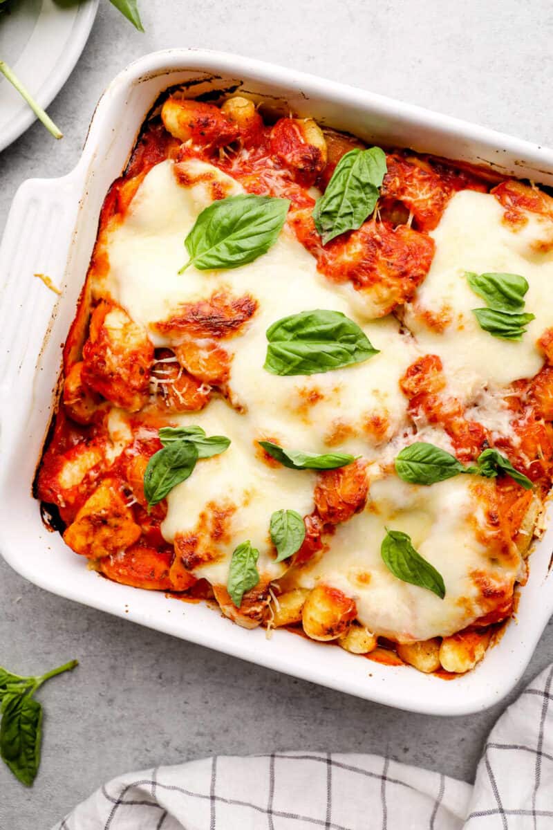 white pan with chicken parm gnocchi bake topped with fresh basil