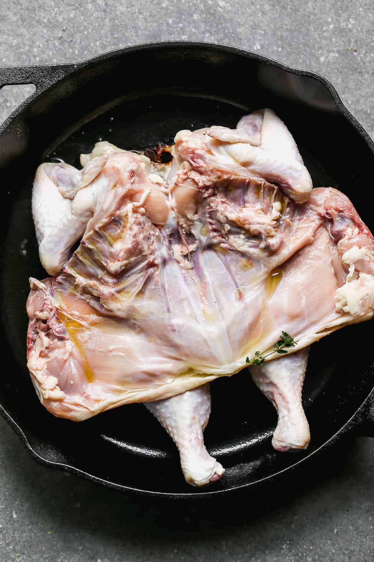 whole chicken flattened in skillet