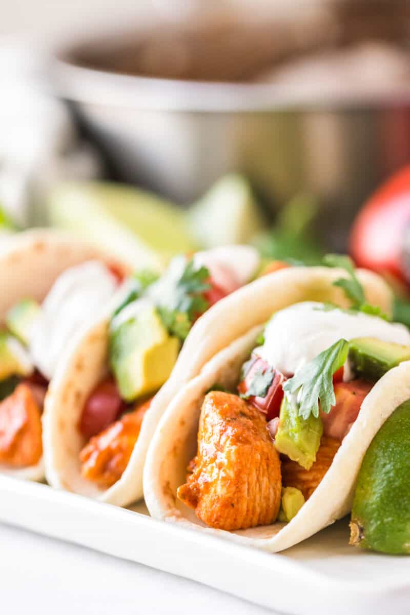 easy chicken tacos topped with avocado and sour cream