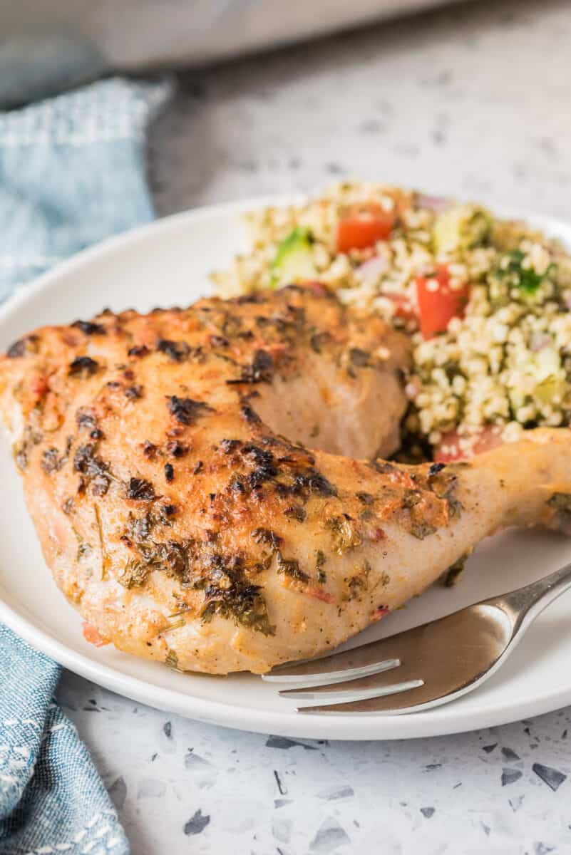 chicken leg on plate next to muesli salad