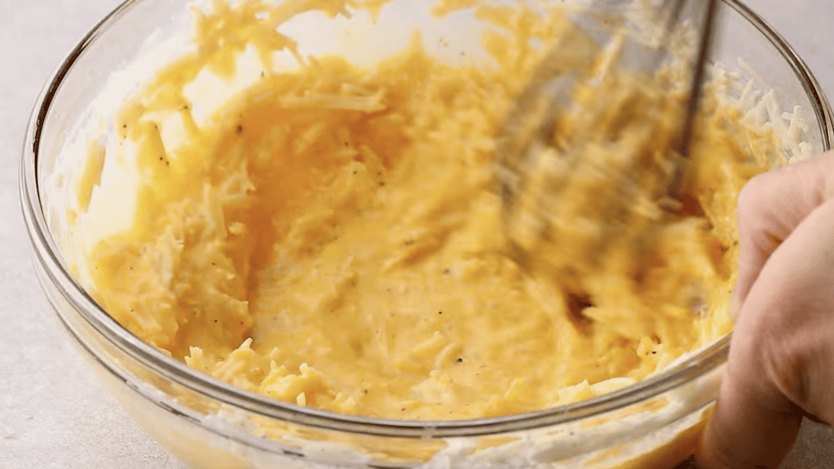 The egg yolk mixture is being whisked in a bowl. 