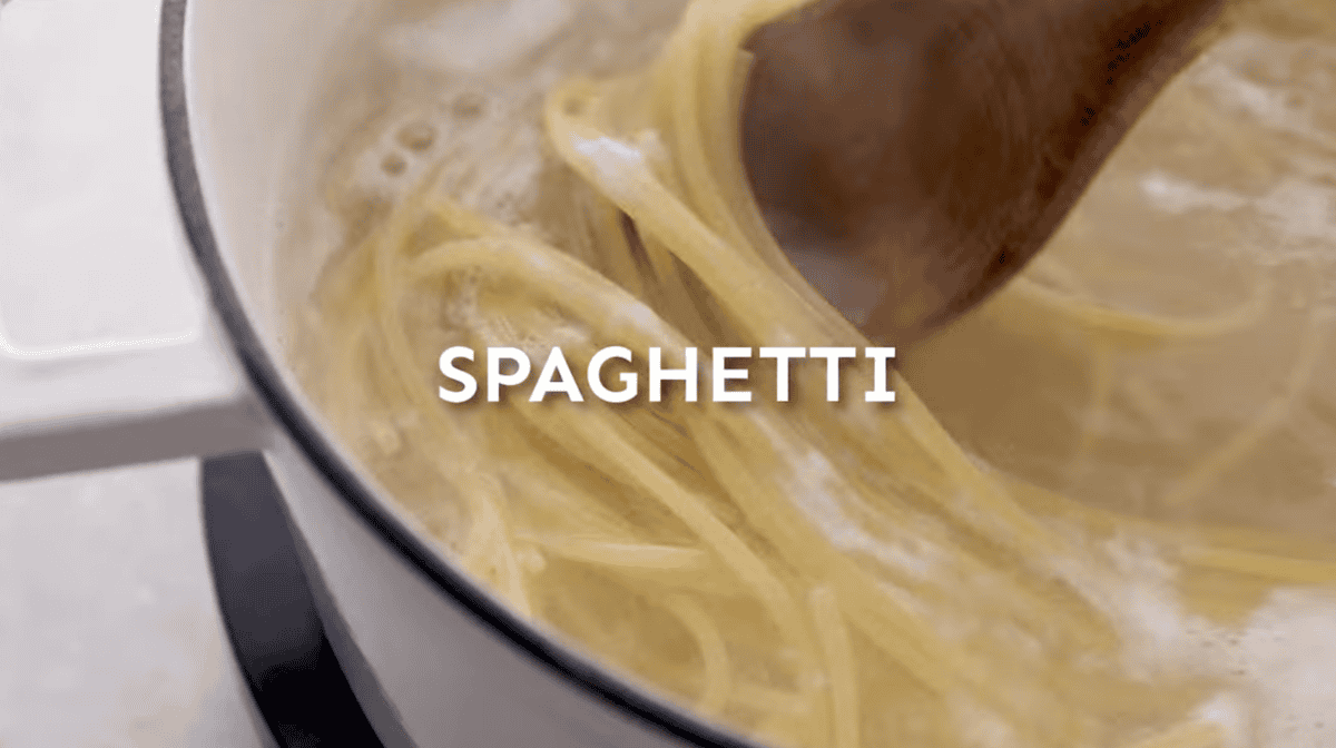 Spaghetti is cooking in a pot. 