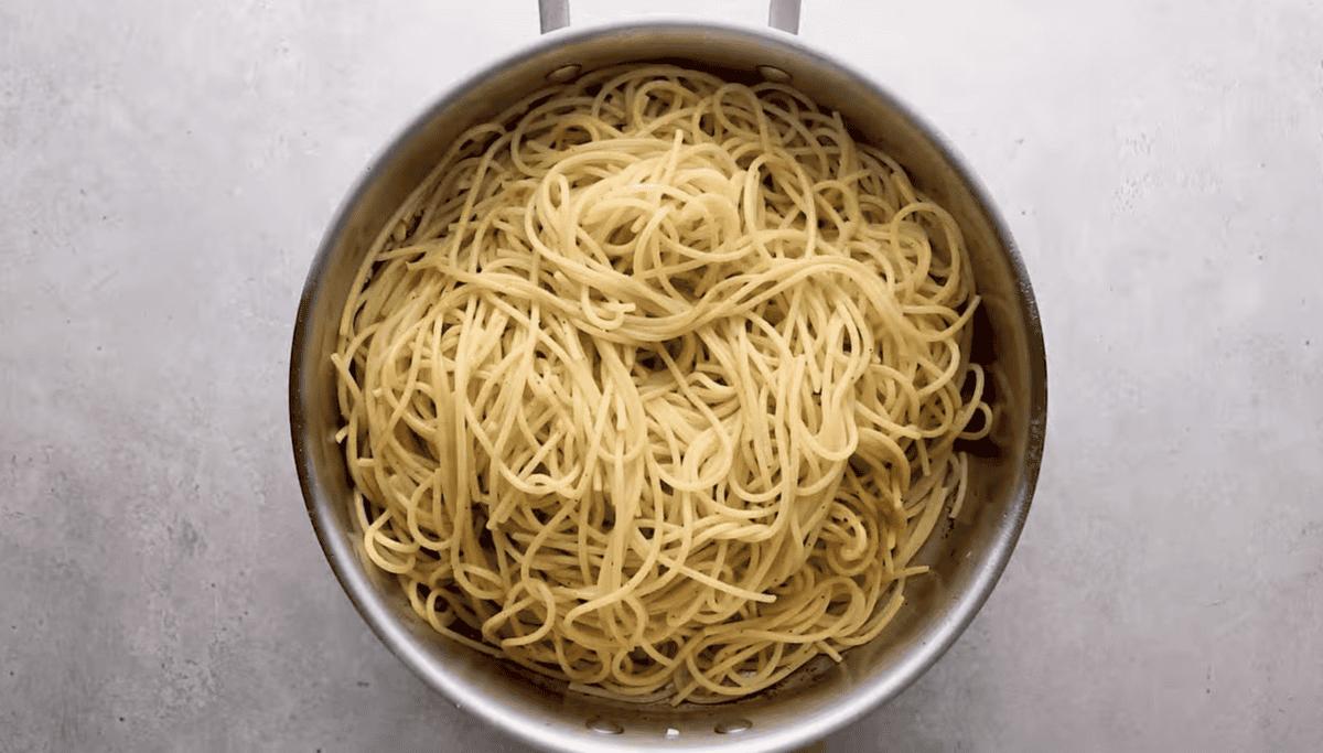 Spaghetti is in a skillet. 