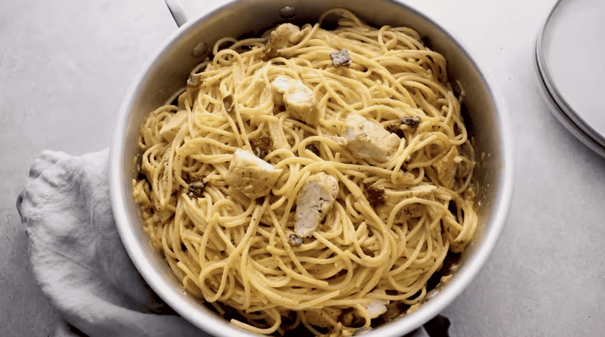 Chicken carbonara is placed in a skillet. 