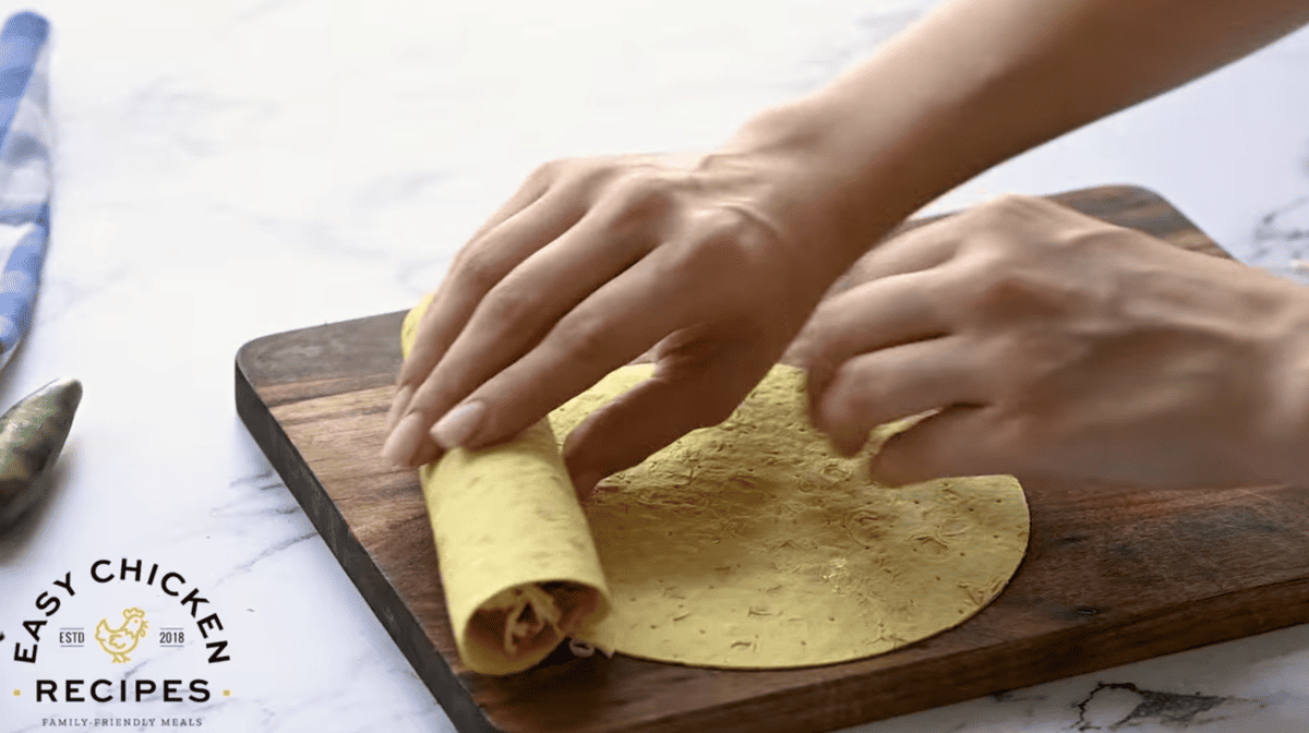 Rolling a flauta filled with shredded chicken.