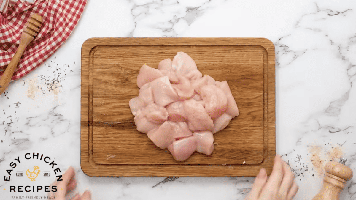 Sliced, raw chicken is on a cutting board. 