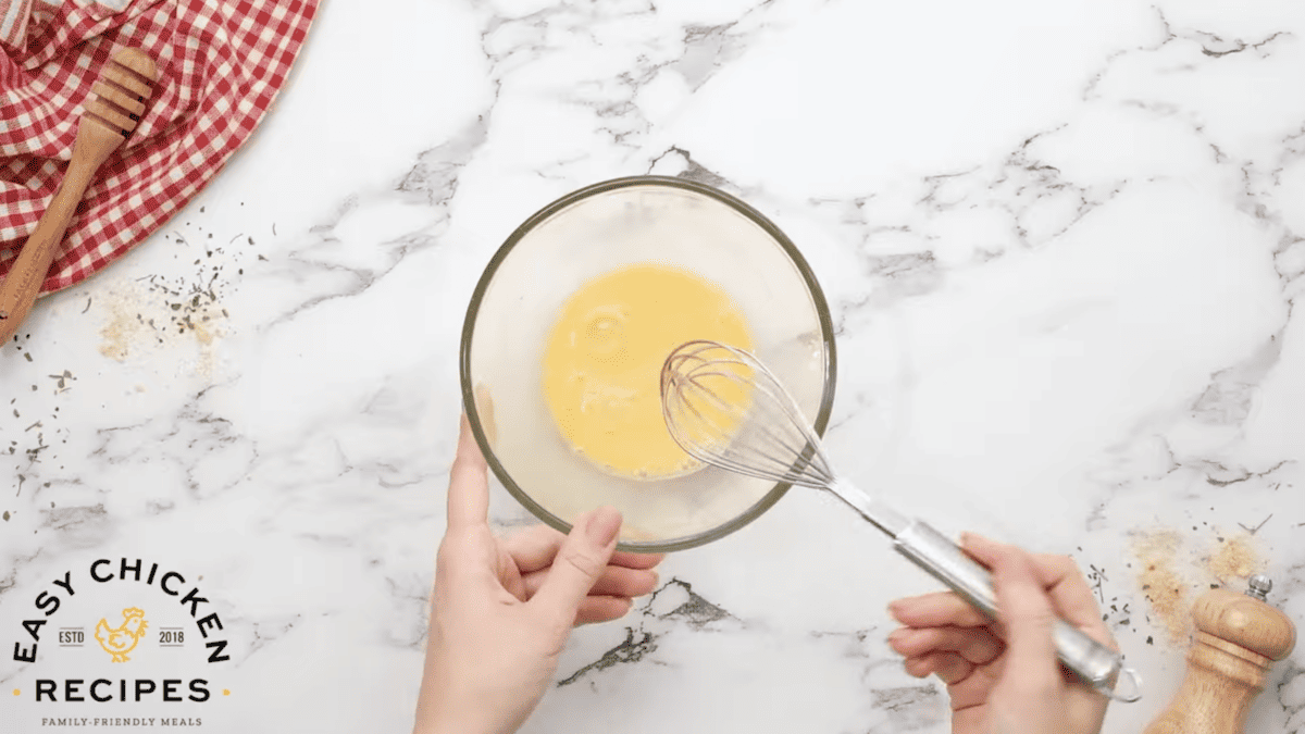 Egg, honey and milk are being whisked in a bowl. 