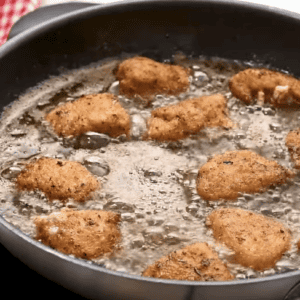 Chicken nuggets are being fried in hot oil.