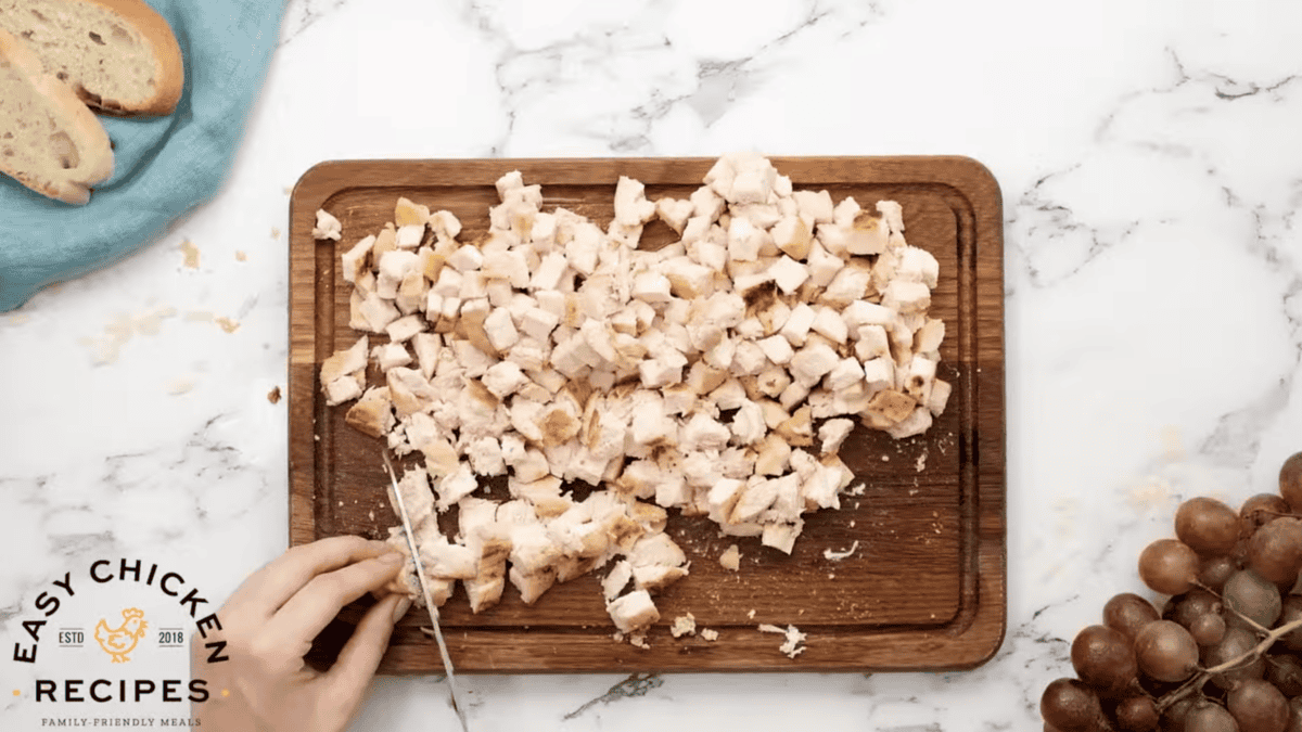 Chopped chicken breast pieces are on a cutting board
