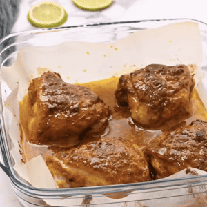 Baked chicken thighs are in a baking dish.