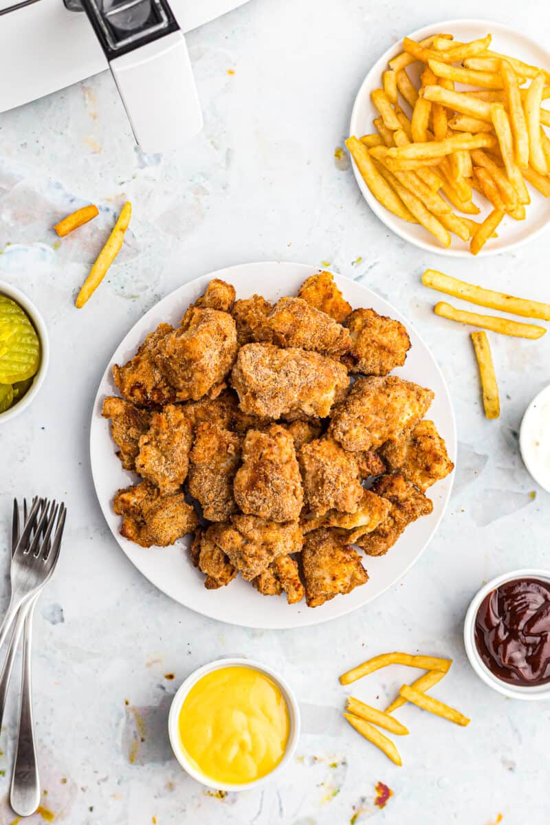 plate of chicken nuggets next to fries