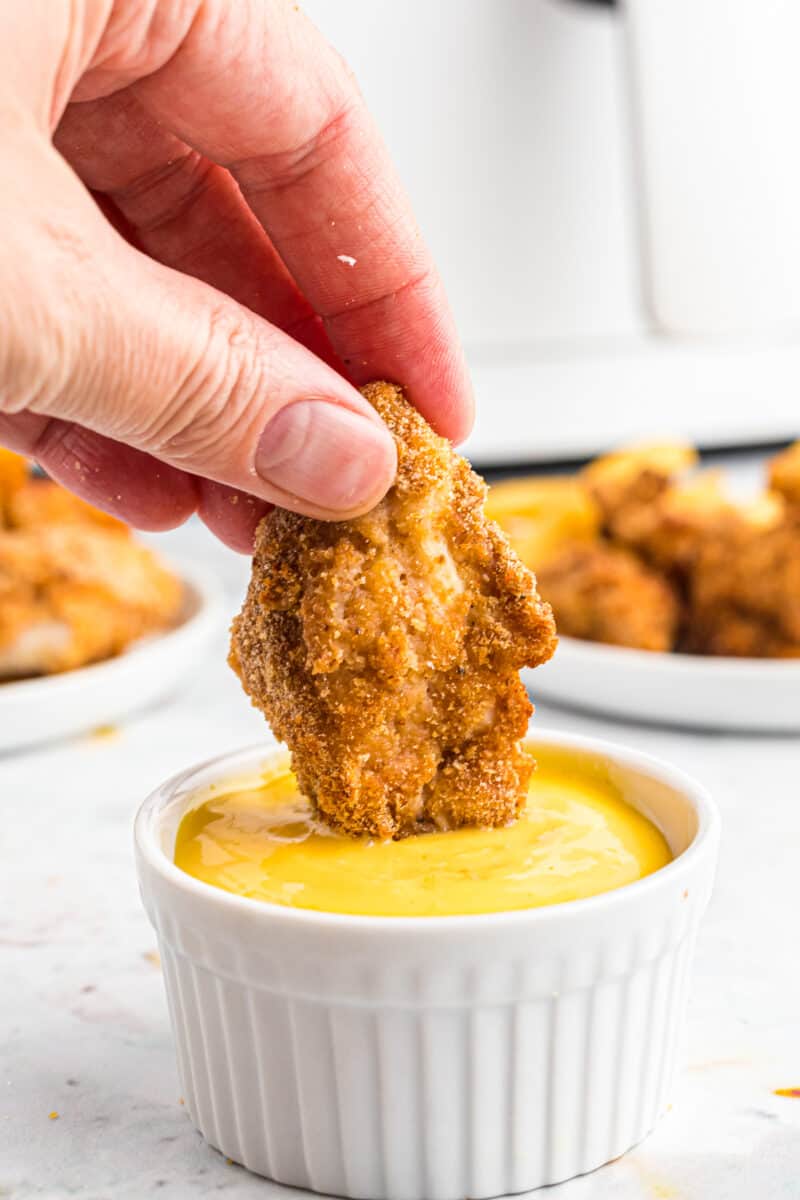dipping air fried chicken nugget in honey mustard