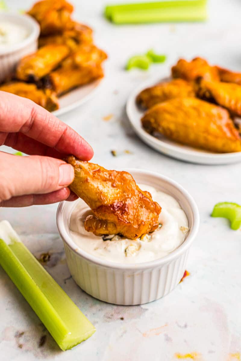dipping air fried chicken wing with buffalo sauce