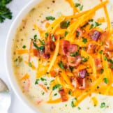 up close image of cheesy chicken chowder garnished with cheese and bacon