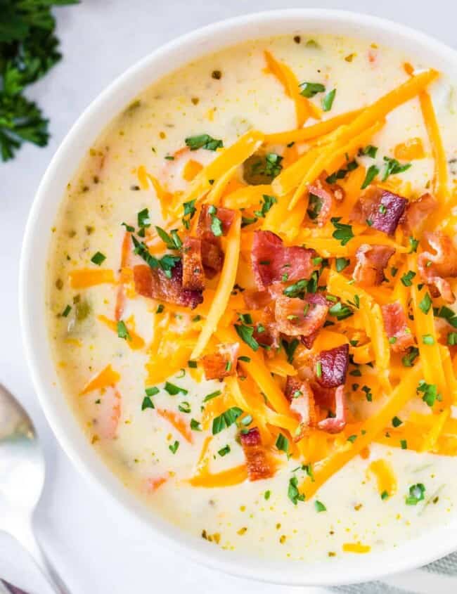 up close image of cheesy chicken chowder garnished with cheese and bacon