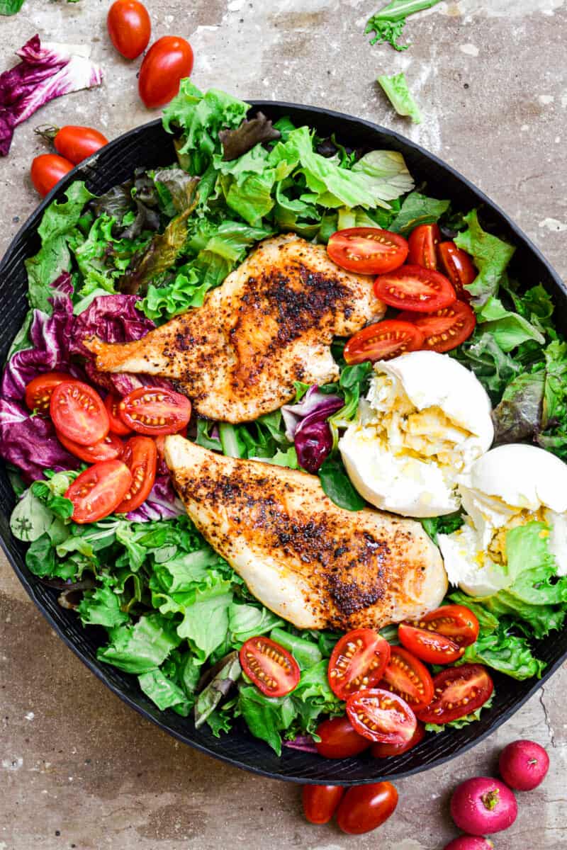 chicken breasts over green salad with burrata