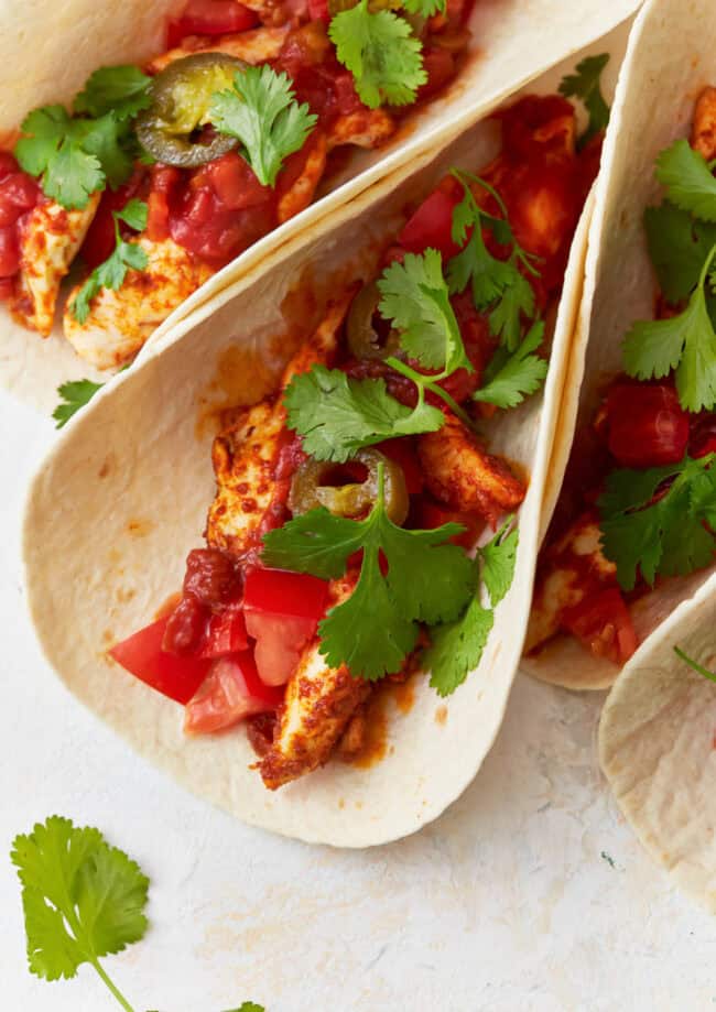 chicken tacos topped with cilantro.