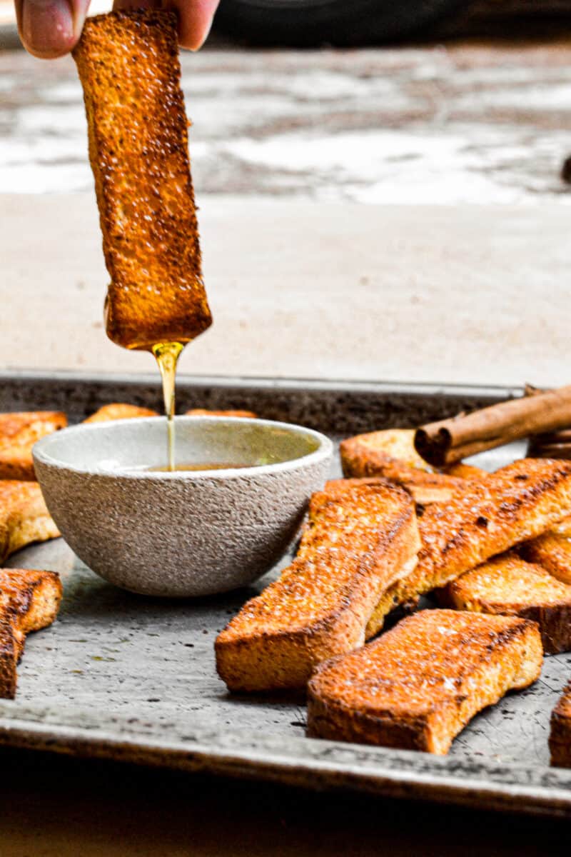 dipping french toast sticks in syrup