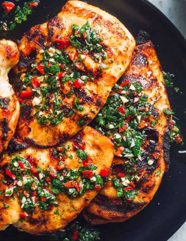 grilled chimichurri chicken on black plate