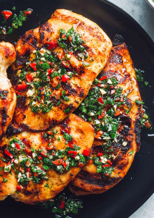 grilled chimichurri chicken on black plate