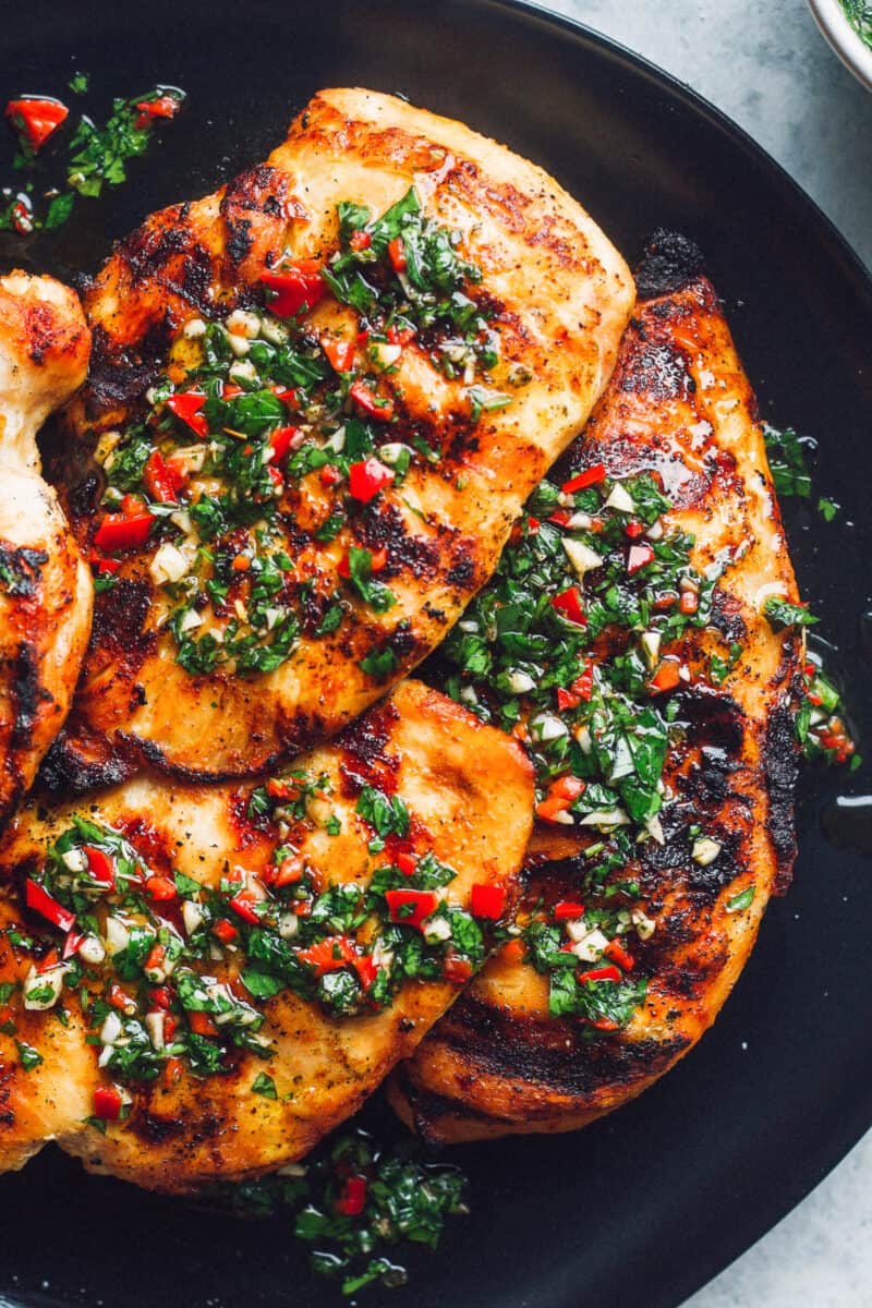 grilled chimichurri chicken on black plate