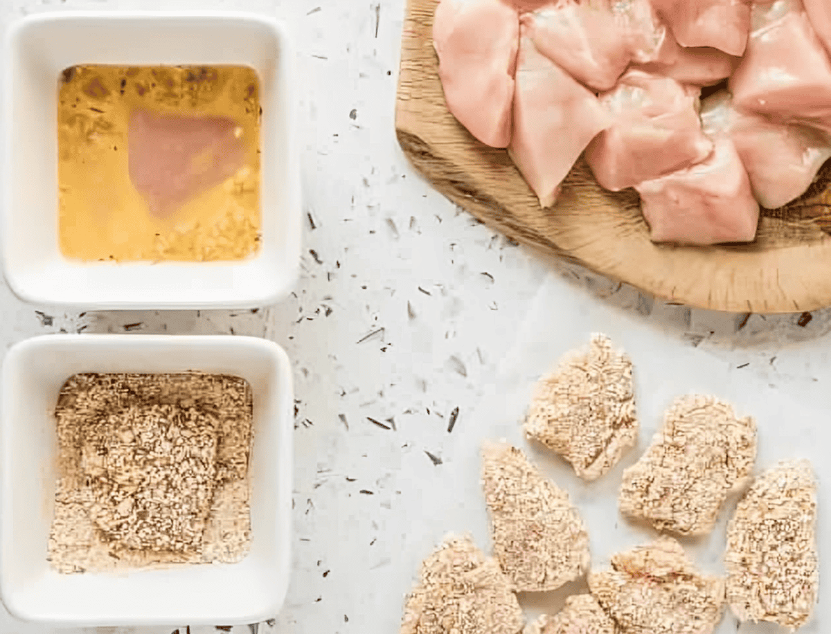 breading cut chicken nuggets in egg and breadcrumbs.