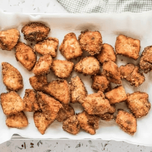 homemade fried chicken nuggets draining on a paper towel.