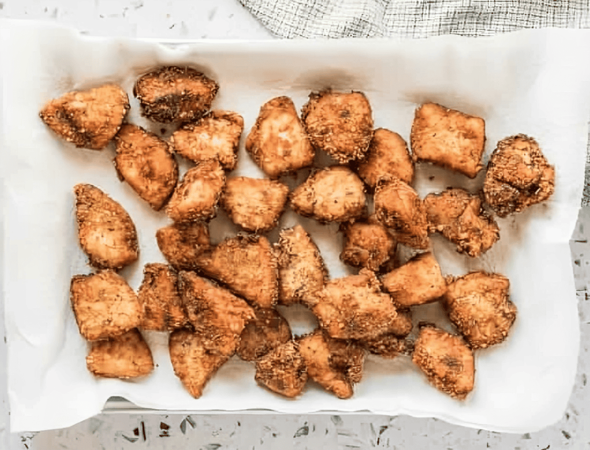 homemade fried chicken nuggets draining on a paper towel.