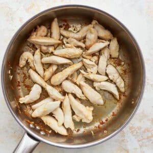 seared chicken strips in a skillet.