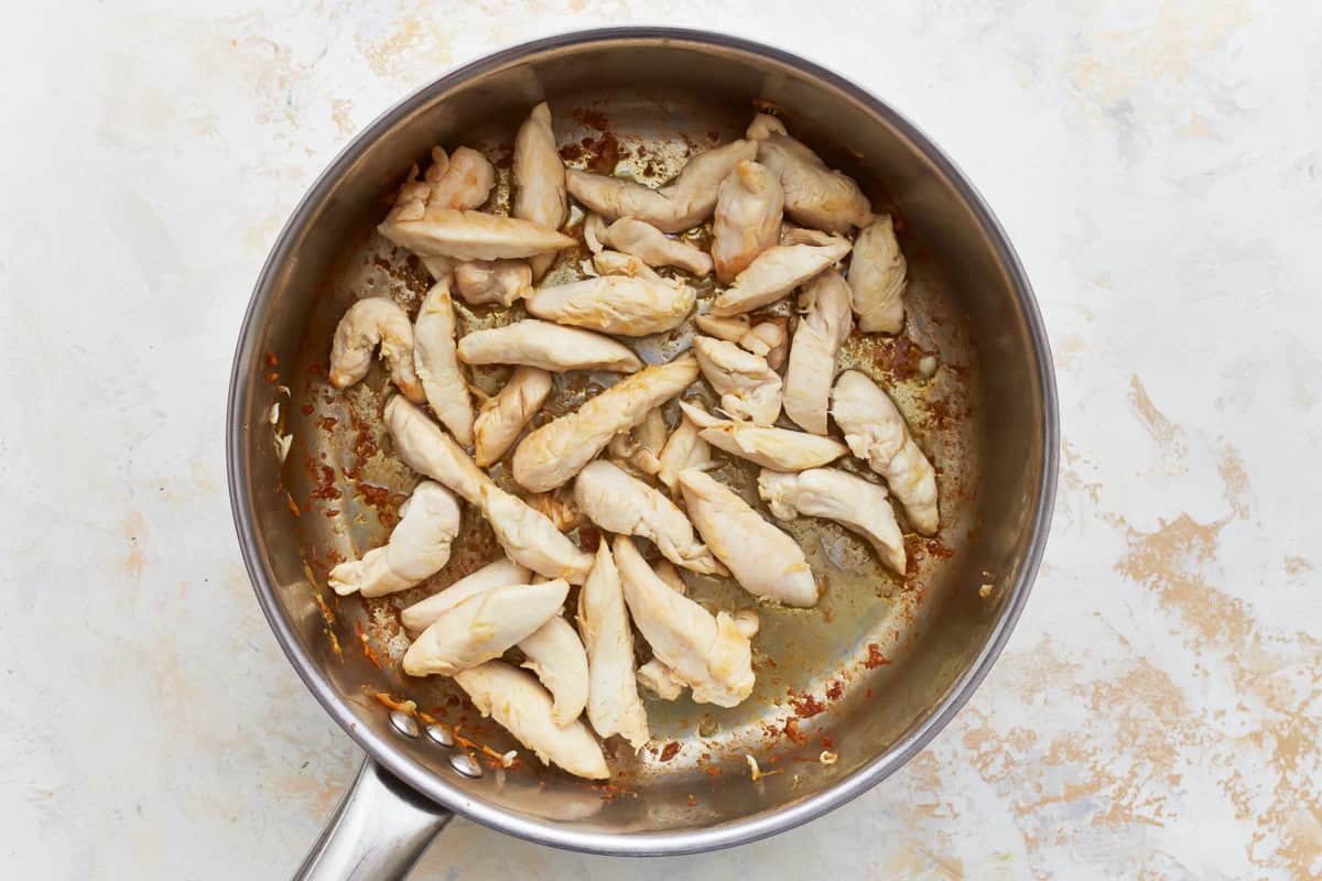 seared chicken strips in a skillet.