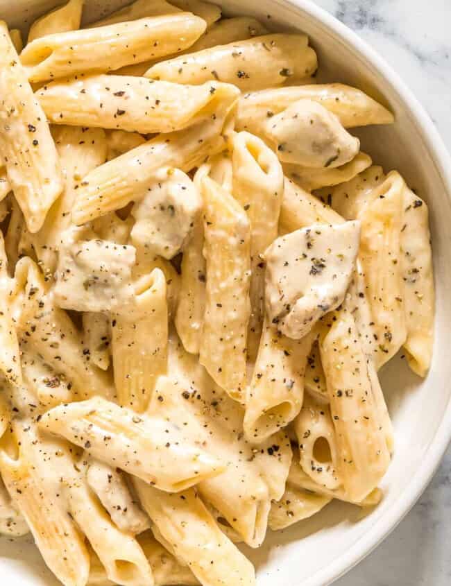 up close image of cheesy chicken pasta in bowl