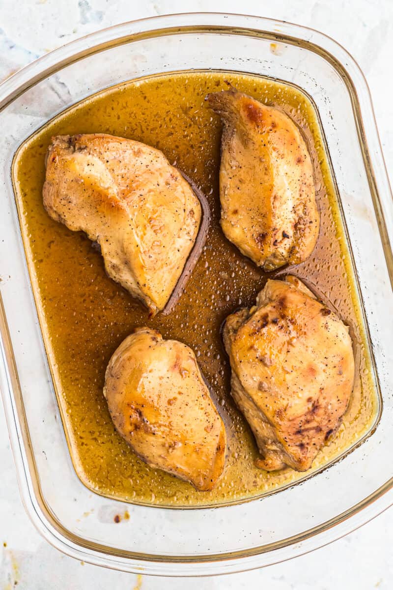 casserole dish with baked maple bourbon chicken breasts