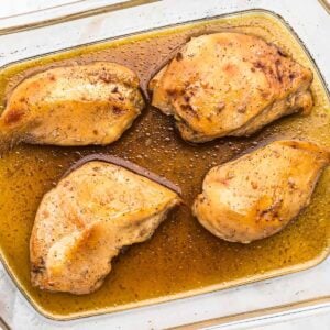 casserole dish with baked maple bourbon chicken breasts