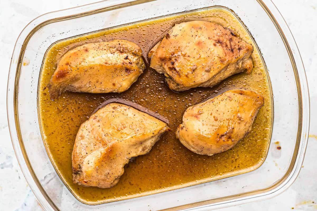 casserole dish with baked maple bourbon chicken breasts