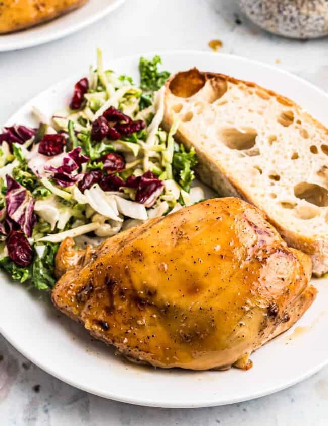 plate of maple bourbon chicken with salad and bread