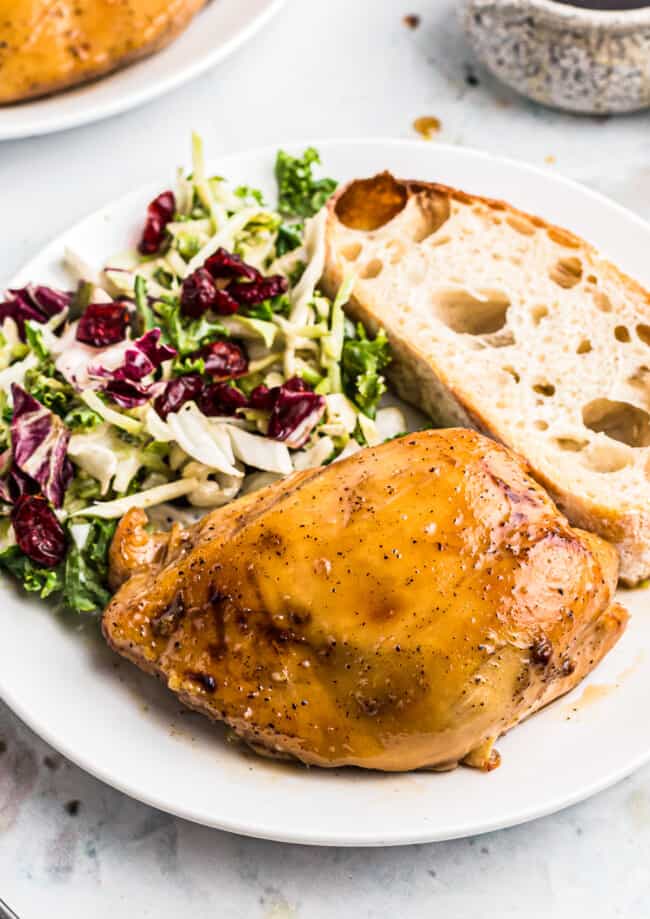 plate of maple bourbon chicken with salad and bread