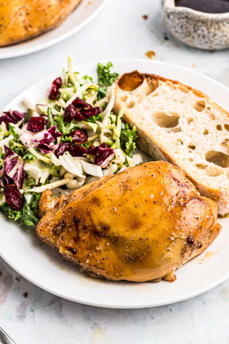 plate of maple bourbon chicken with salad and bread