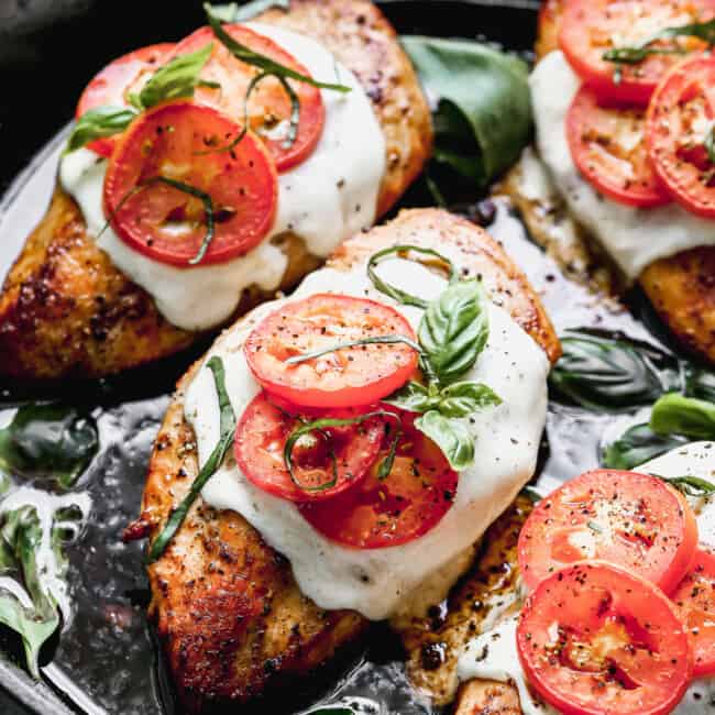 chicken topped with mozzarella basil and tomato in skillet