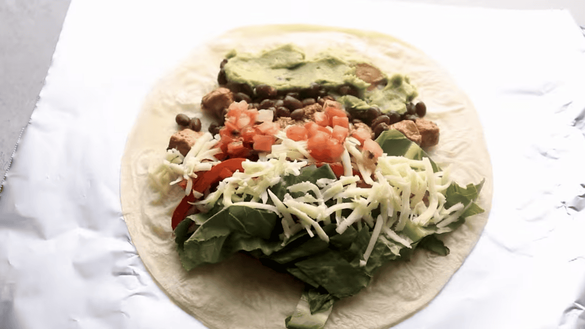 Ingredients are placed on top of a tortilla. 