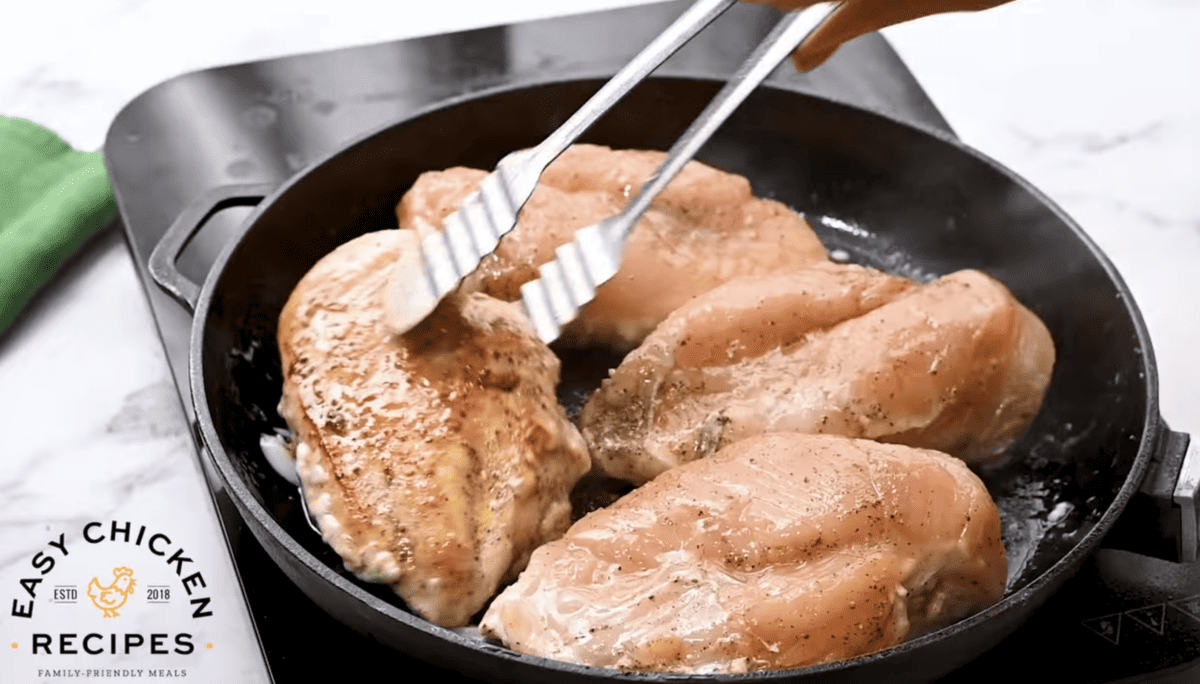 Chicken is being seared in a pan.