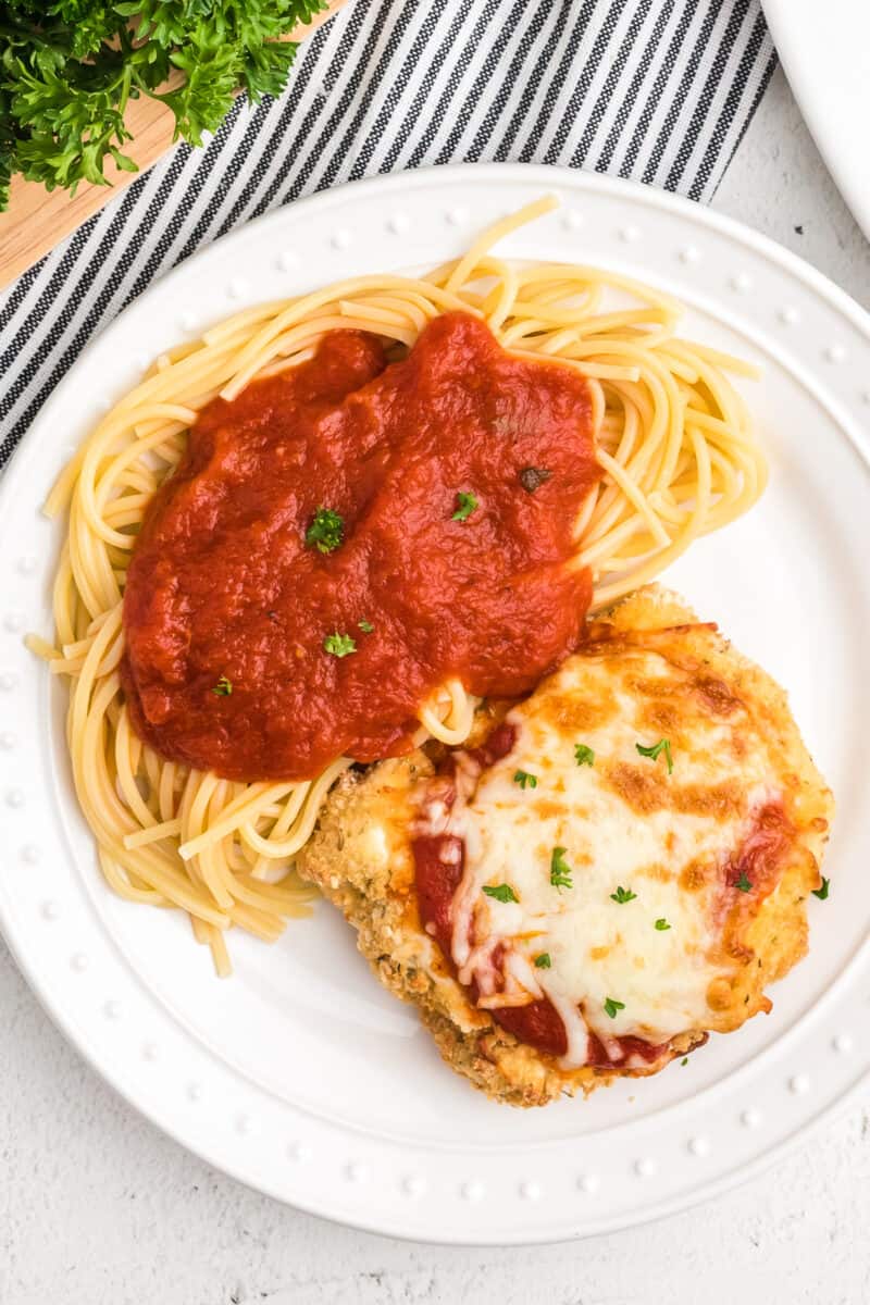 air fryer chicken parmesan next to spaghetti and sauce