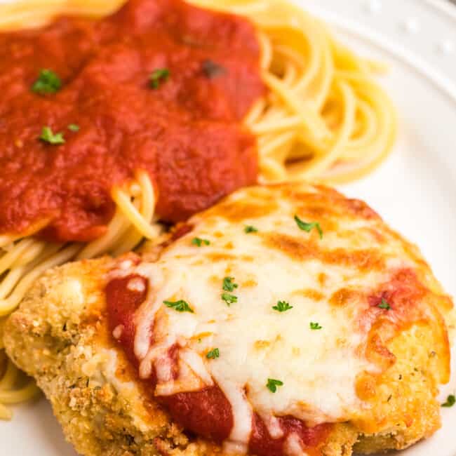 white plate with air fryer chicken parmesan with pasta