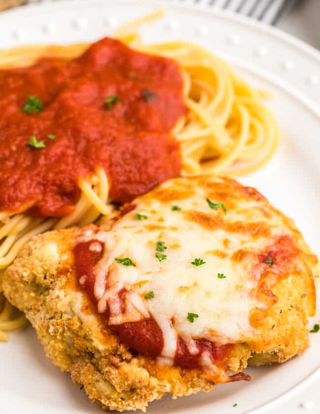 white plate with air fryer chicken parmesan with pasta