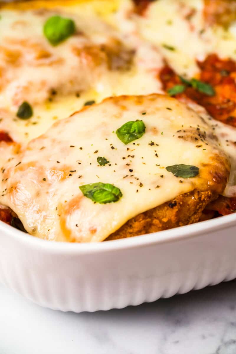 chicken parmesan topped with cheese in baking dish